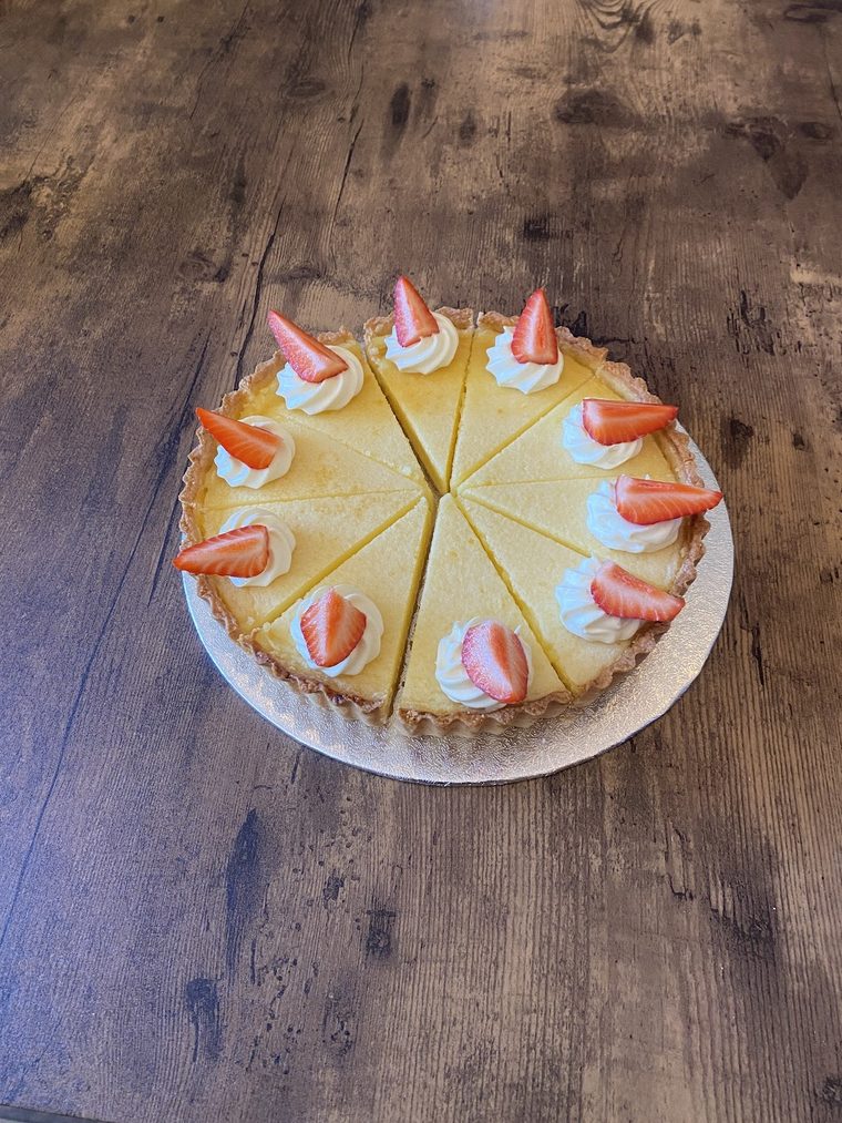 Strawberry-topped custard tart, sliced into portions
